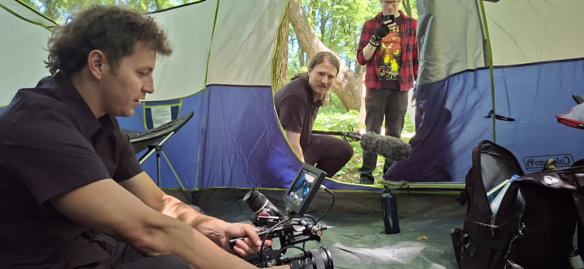 Emergency Pineapple Studios crew setting up camera inside a tent on location in the Upper Midwest